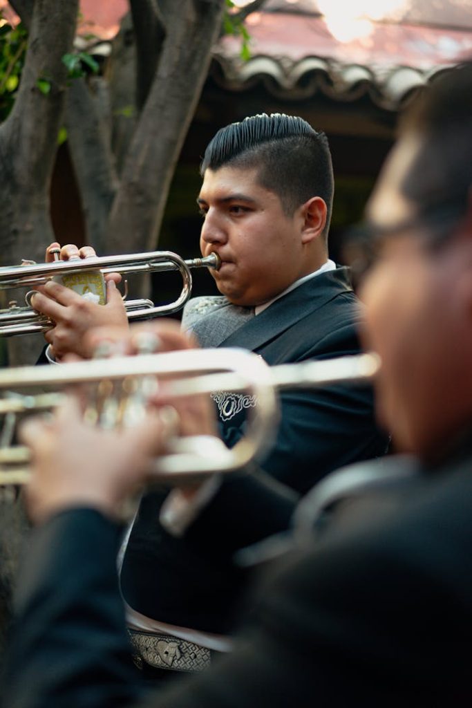 Mariachi musicians performing with trumpets in traditional Mexican attire outdoors.